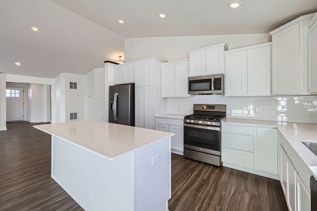 kitchen featuring stainless steel appliances, light countertops, and white cabinetry