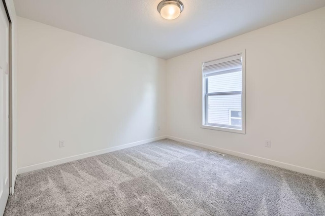 spare room featuring carpet flooring and baseboards