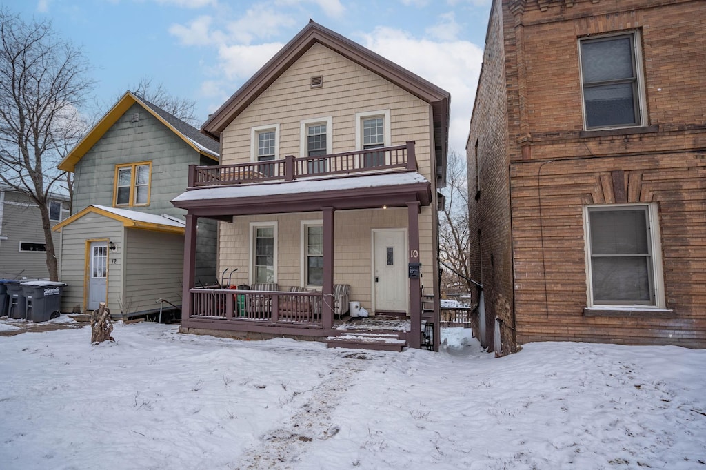 view of property with a porch and a balcony