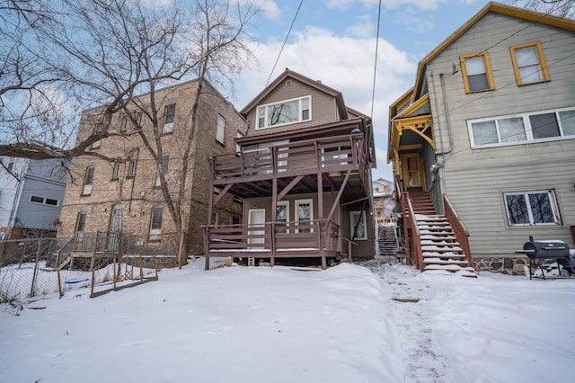 snow covered rear of property featuring a deck