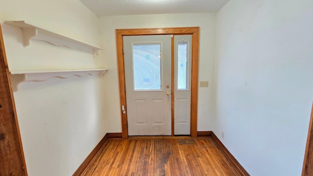 doorway to outside featuring hardwood / wood-style floors and a textured ceiling