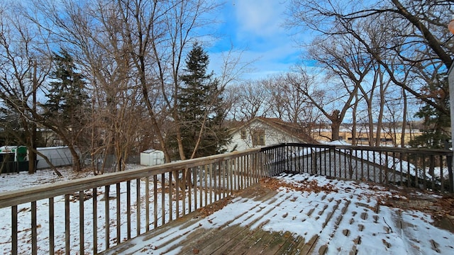 snow covered deck featuring a shed