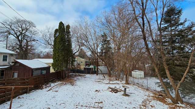 yard layered in snow with a storage unit