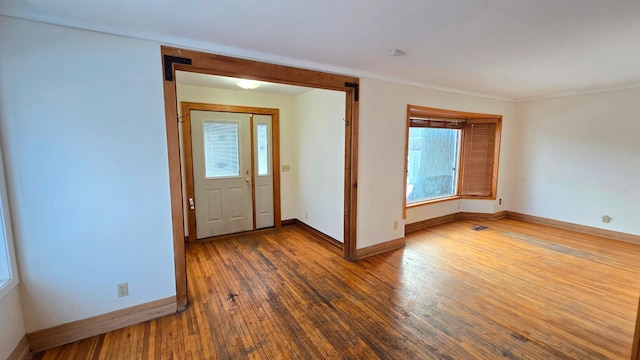 foyer entrance with hardwood / wood-style flooring, plenty of natural light, and baseboards