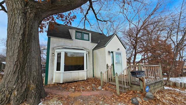 view of front of house with roof with shingles and stucco siding