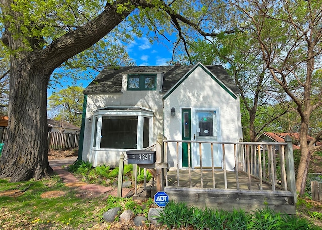 3343 Drew Ave N, Robbinsdale, MN 55422 - view of front of home featuring stucco siding, a deck, fence, and roof with shingles