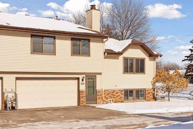 view of front of property with a garage, driveway, and a chimney