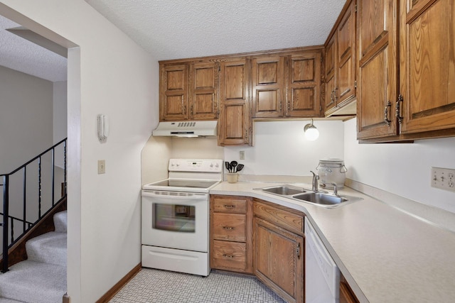 kitchen featuring light countertops, brown cabinetry, a sink, white appliances, and under cabinet range hood