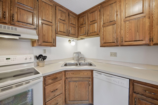 kitchen featuring white appliances, extractor fan, a textured ceiling, light countertops, and a sink