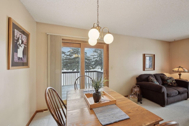 dining room featuring a textured ceiling, carpet floors, an inviting chandelier, and baseboards