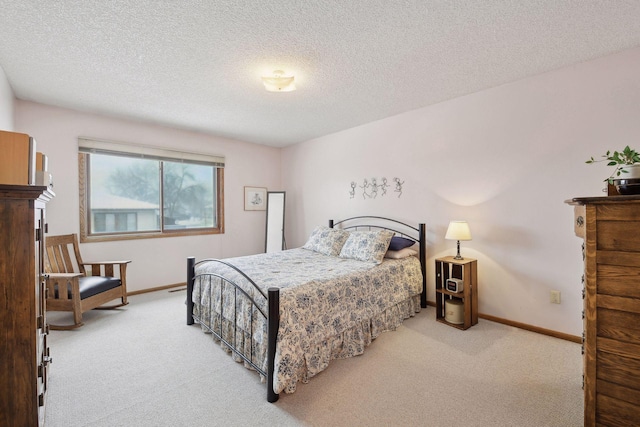 bedroom with light carpet, baseboards, and a textured ceiling