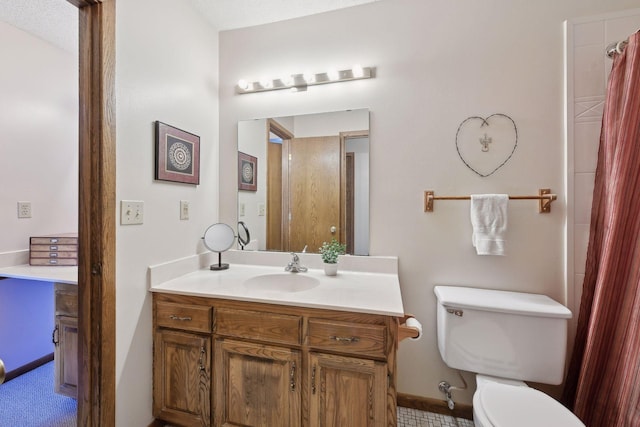 bathroom featuring vanity, toilet, and baseboards