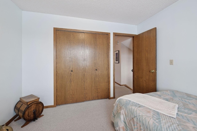 bedroom featuring a textured ceiling, a closet, carpet, and baseboards