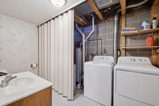 clothes washing area featuring wallpapered walls, laundry area, washer and clothes dryer, and a sink