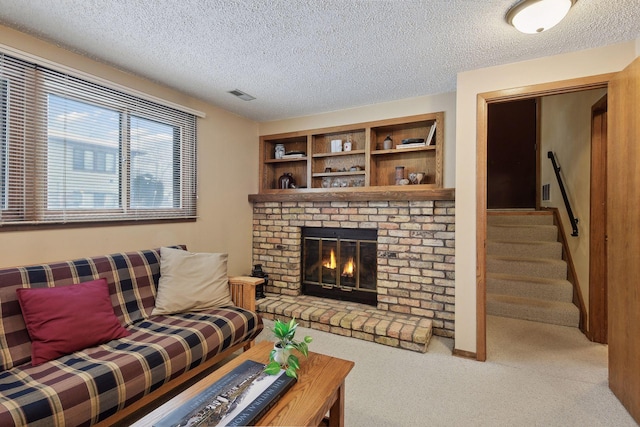 carpeted living room featuring visible vents, a fireplace, stairway, and a textured ceiling