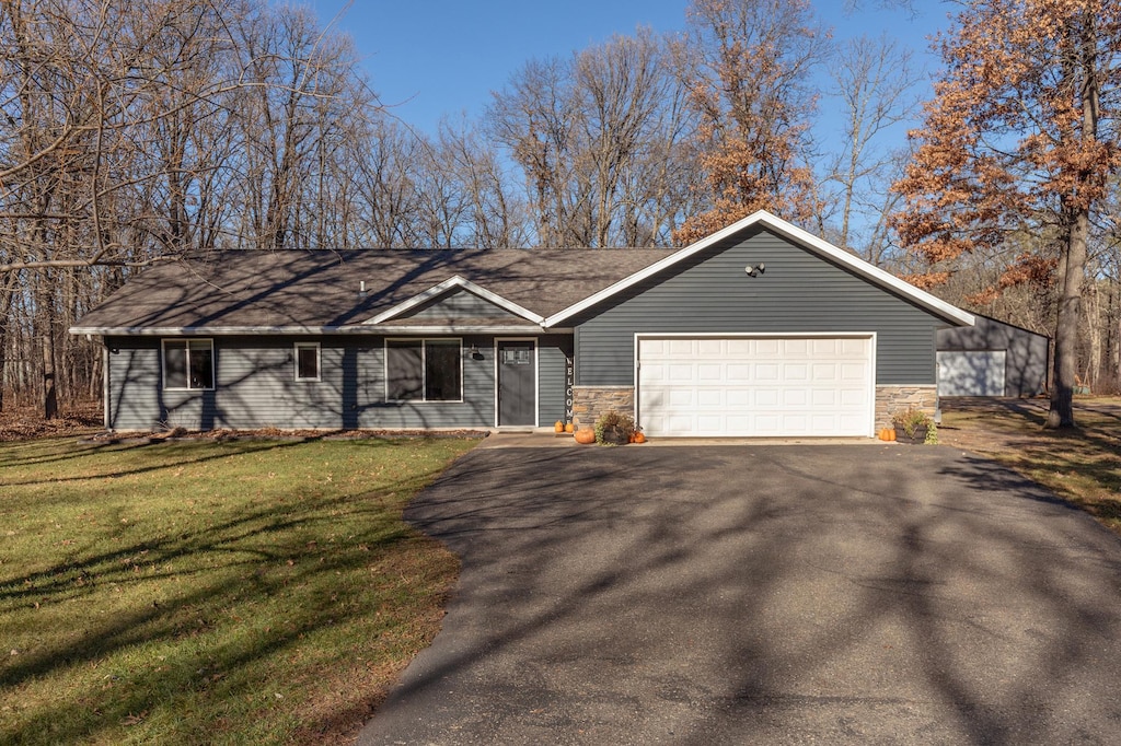 ranch-style home featuring a garage and a front yard