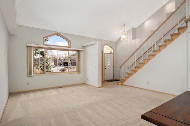 unfurnished living room featuring light carpet, baseboards, visible vents, stairs, and high vaulted ceiling