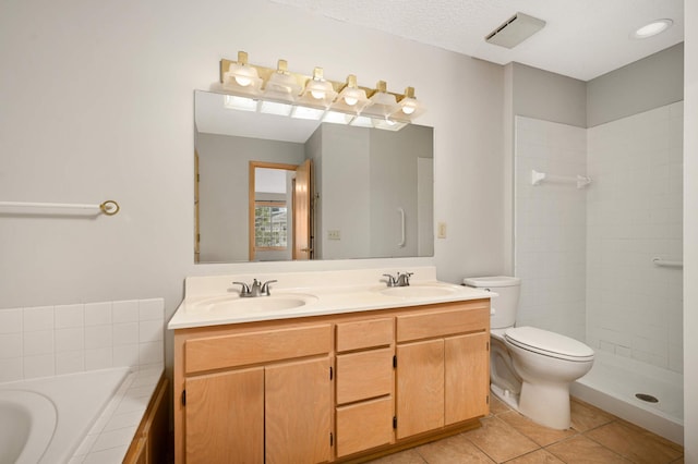 full bath with a garden tub, a sink, toilet, and tile patterned floors