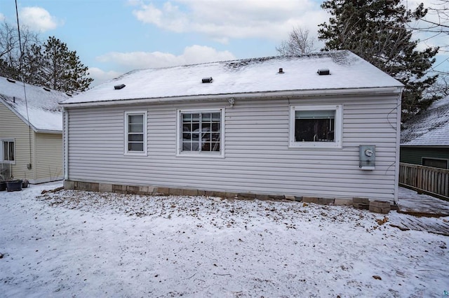 view of snow covered rear of property