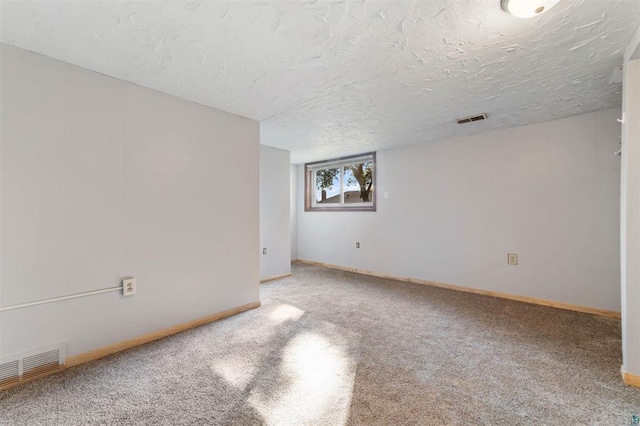 carpeted empty room featuring a textured ceiling