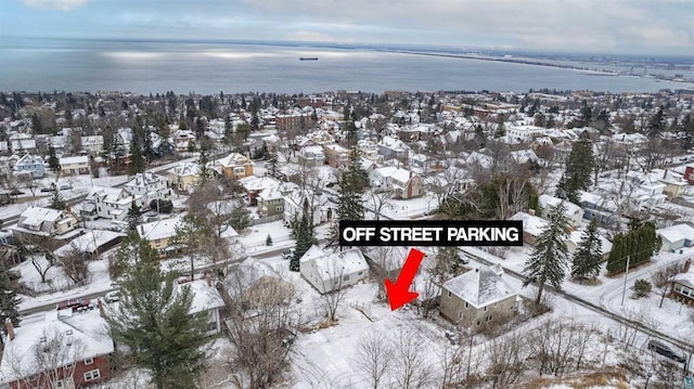 snowy aerial view featuring a water view