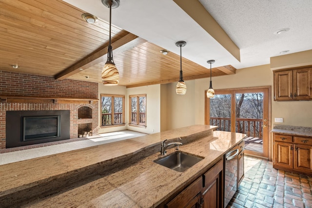 kitchen with beamed ceiling, brick floor, a sink, and a healthy amount of sunlight