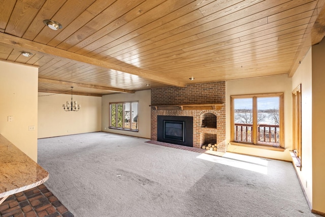 unfurnished living room with a chandelier, a brick fireplace, carpet flooring, and wooden ceiling