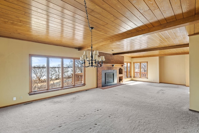 unfurnished living room featuring a fireplace, carpet flooring, visible vents, beamed ceiling, and an inviting chandelier