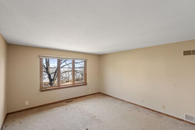 carpeted empty room with visible vents and baseboards