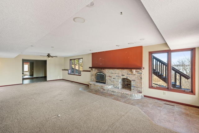 unfurnished living room with carpet, a fireplace, baseboards, and a textured ceiling