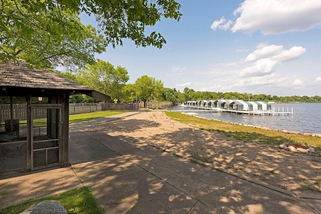 exterior space with a dock, a water view, and fence