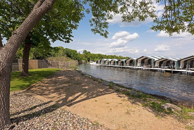 dock area featuring a residential view, a water view, and fence