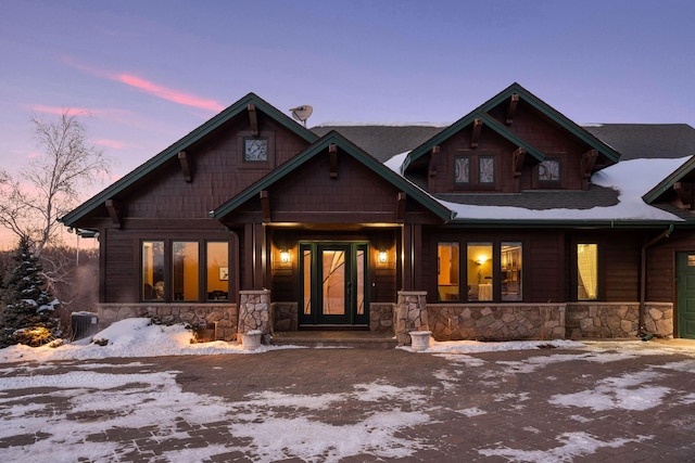 view of front facade with stone siding and central AC