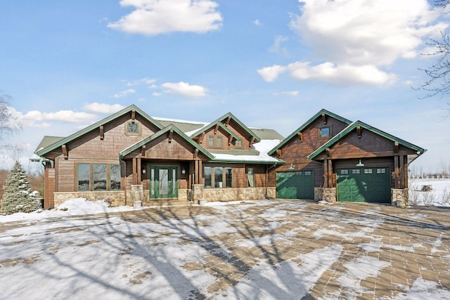 view of front of home featuring a garage, stone siding, french doors, and decorative driveway