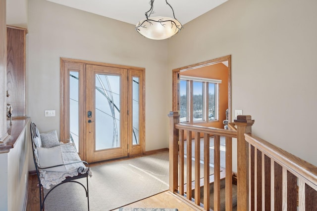 carpeted foyer entrance featuring baseboards