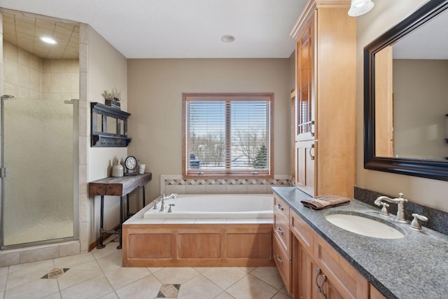 full bath featuring a stall shower, tile patterned flooring, a garden tub, and vanity