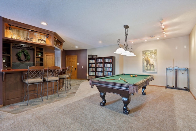 rec room featuring pool table, bar area, a textured ceiling, and light colored carpet