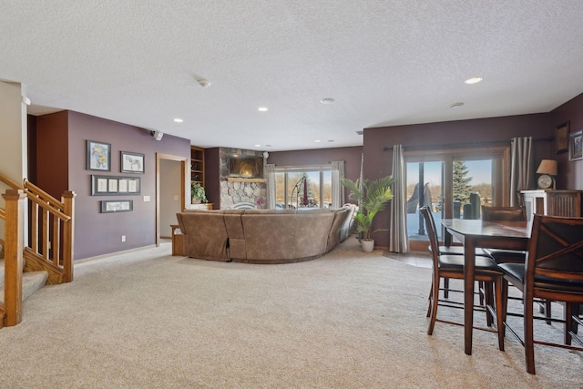 living room with a textured ceiling, recessed lighting, light carpet, baseboards, and stairs