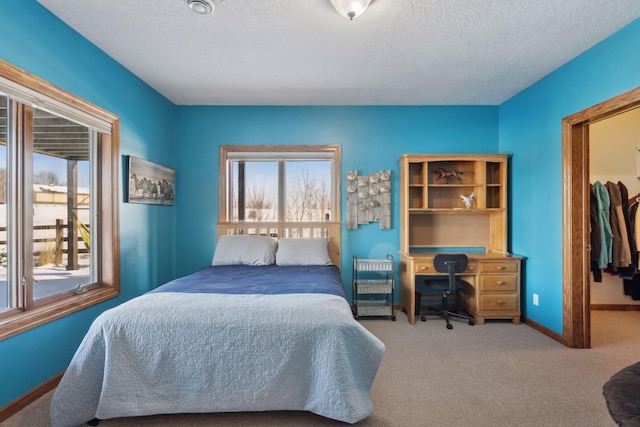 bedroom featuring carpet, a textured ceiling, and baseboards