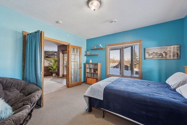 bedroom with light carpet, french doors, and a textured ceiling