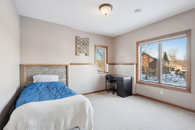 bedroom featuring light carpet and baseboards