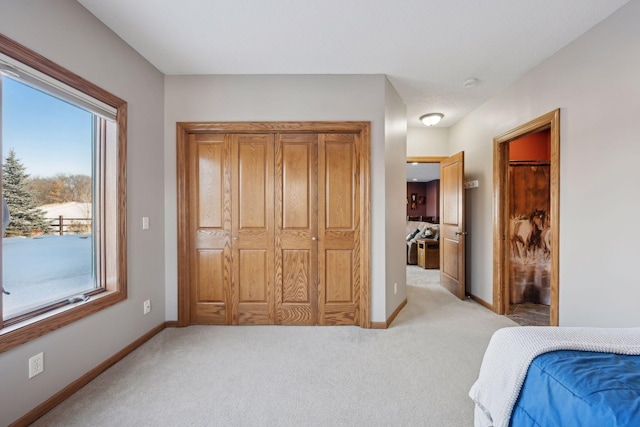 bedroom with baseboards and light colored carpet