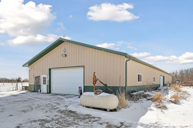 snow covered garage featuring a detached garage