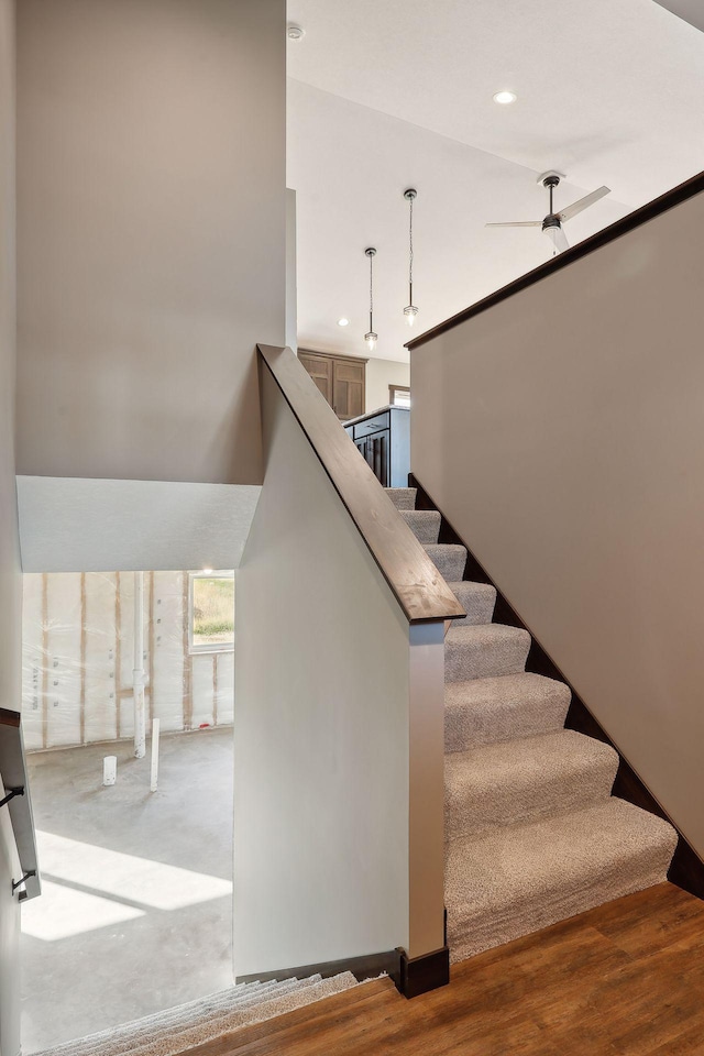 stairs with ceiling fan and hardwood / wood-style floors