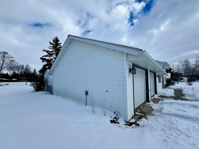 view of snowy exterior with a garage