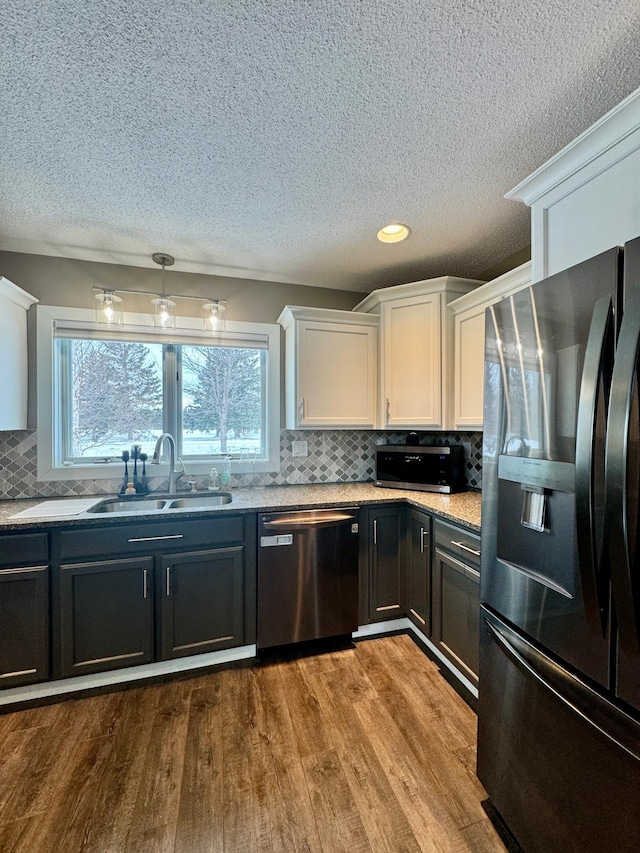 kitchen with white cabinetry, appliances with stainless steel finishes, light hardwood / wood-style floors, and sink