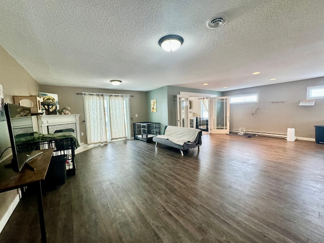 living room featuring a brick fireplace, a textured ceiling, and dark hardwood / wood-style flooring