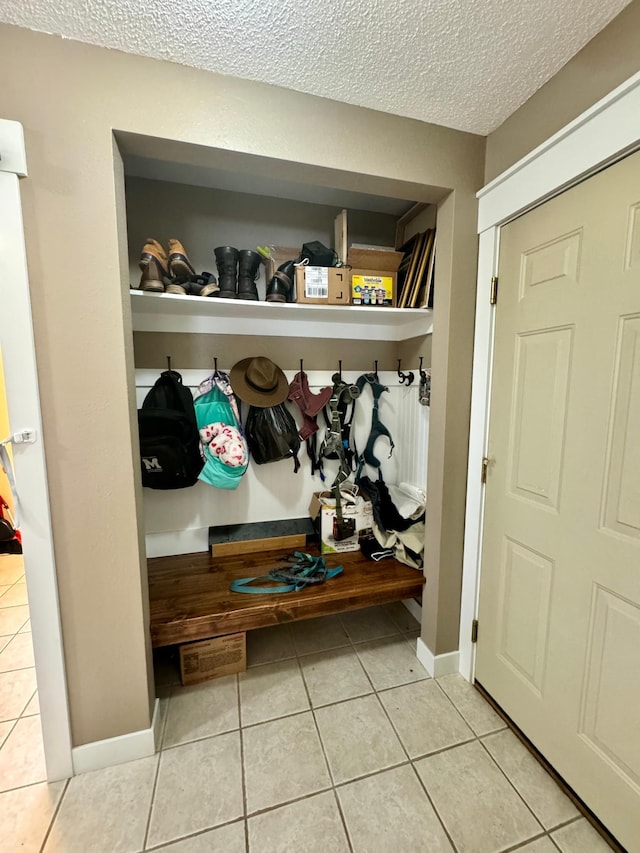 mudroom featuring a textured ceiling and light tile patterned floors