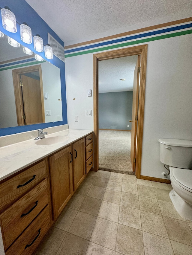 bathroom featuring vanity, toilet, and a textured ceiling