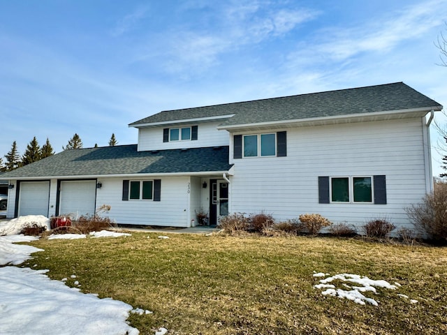 traditional home featuring a front yard, an attached garage, and a shingled roof